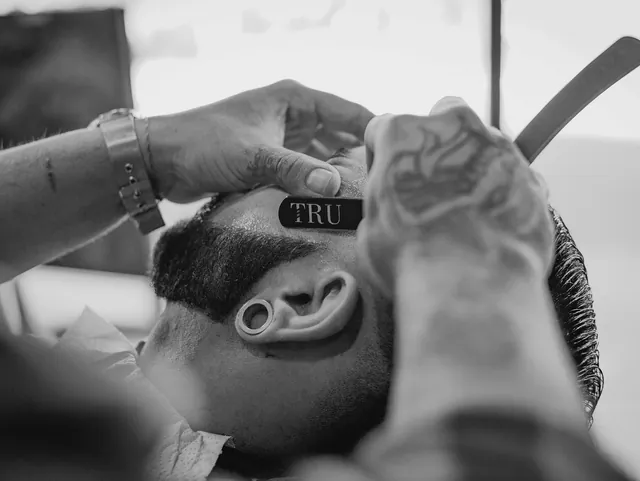 Navalha acertando o contorno da barba, perto da orelha